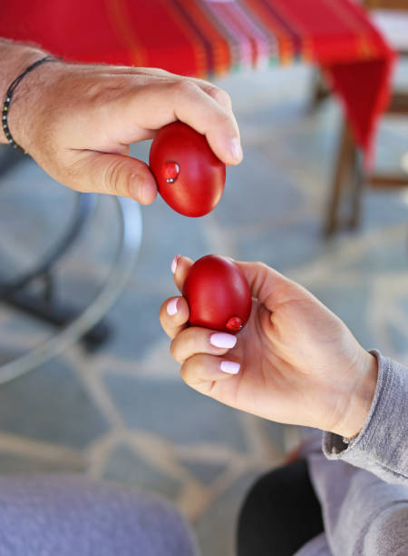 istock hands holding cracked red Easter eggs - Orthodox greek tradition of cracking eggs - symbolizes Christ resurrection 1216017872