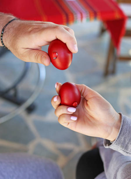 hands holding cracked red Easter eggs - Orthodox greek tradition of cracking eggs - symbolizes Christ resurrection stock photo