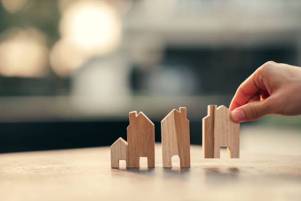 hand of woman choosing mini wood house model, planning buy real estate, eco house icon concept. - house human hand choice real estate imagens e fotografias de stock