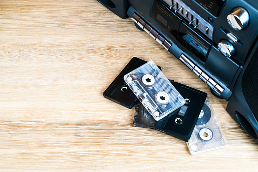 Old audio cassettes and a player on a wooden table