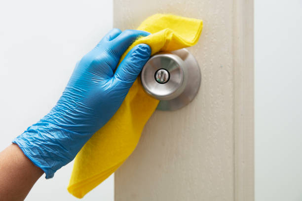 istock Hands with glove wiping doorknob. 1216021000
