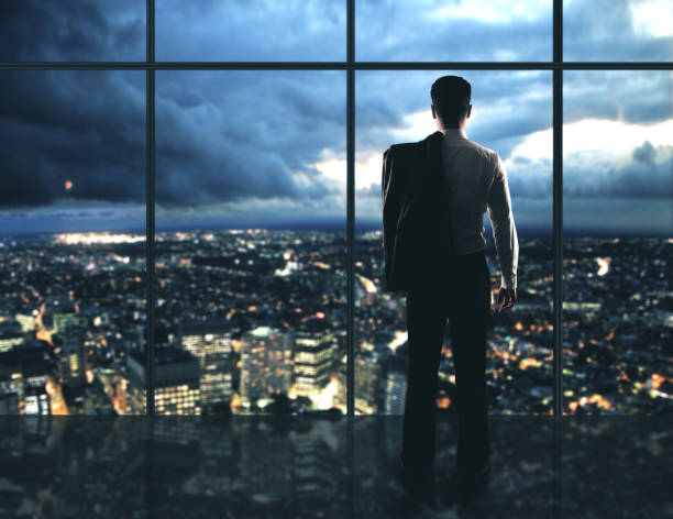 istock Businessman standing in night offic 1216021262