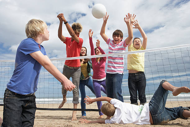 adolescentes jogando voleibol - beach volleying ball playing imagens e fotografias de stock