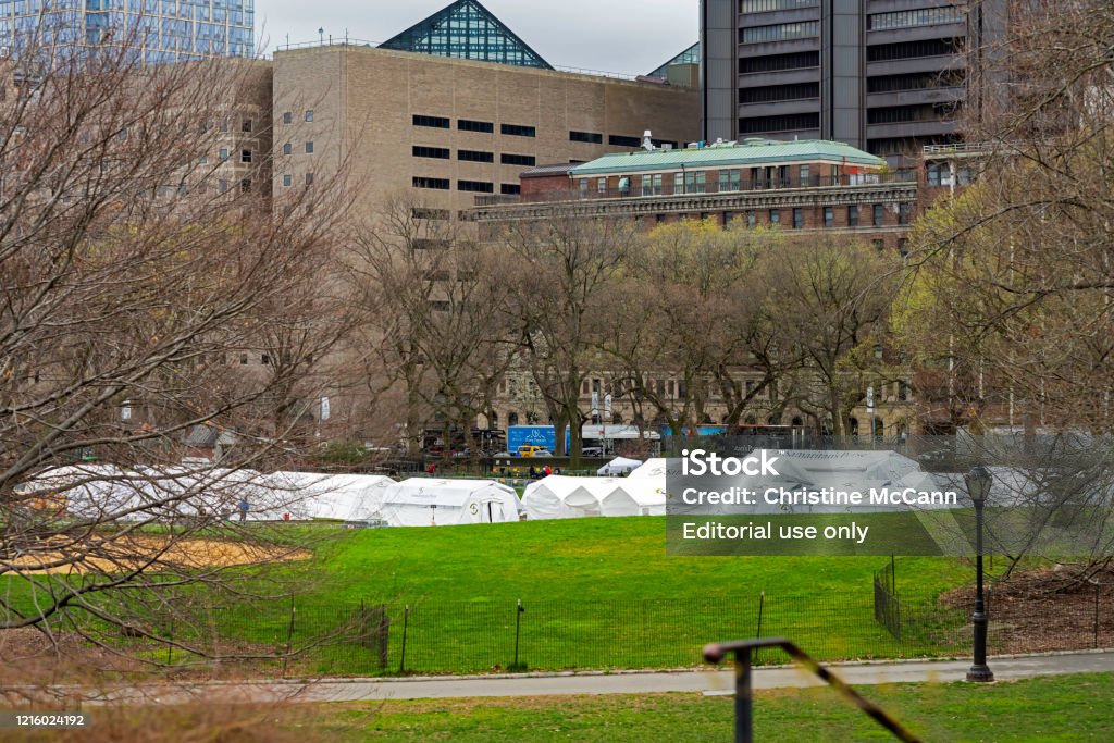 Hospital Tents in Central Park’s East Meadow New York, NY, USA - March 31, 2020: Hospital tents erected in the East Meadow of Manhattan's Central Park, opposite the Mount Sinai Hospital on Fifth Avenue, to help battle the ongoing coronavirus pandemic. Hospital buildings can be seen beyond the tents. Mount Sinai Hospital - Manhattan Stock Photo