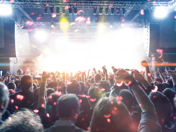 istock Concert stage, people are visible waving and clapping, silhouettes are visible 1216025875