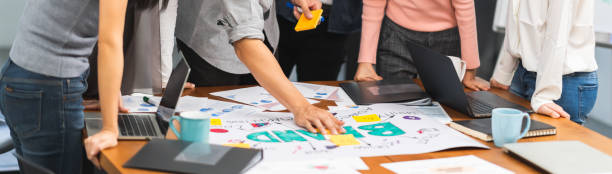 equipo creativo asiático joven trabajan juntos en la reunión de lluvia de ideas, proyecto de diseño de marca de negocio. oficina moderna, compañero de trabajo, investigación de publicidad de marketing o concepto de trabajo en equipo de productividad - urbanscape fotografías e imágenes de stock