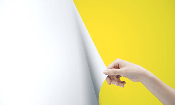 istock Woman hand turning yellow page 1216028941