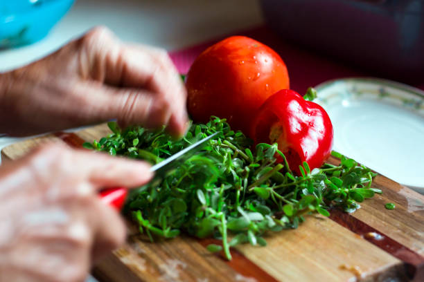 View of Preparation of a traditional Mediterranean salad with tomatoes, rocket leaves, pursley, cucumber, onion and lettuce served in olive oil, lemon and vinegar.