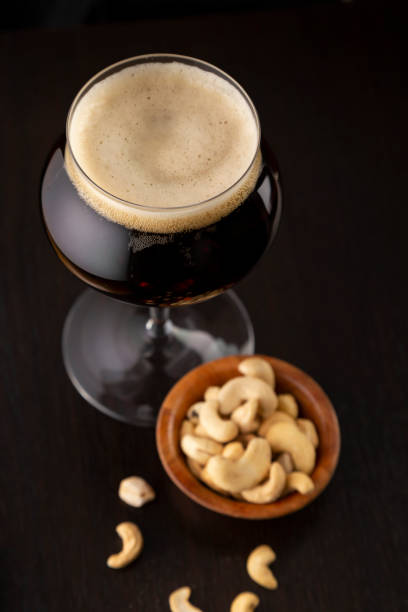 ciemne piwo i cahsews - cashew beer nuts nut food zdjęcia i obrazy z banku zdjęć