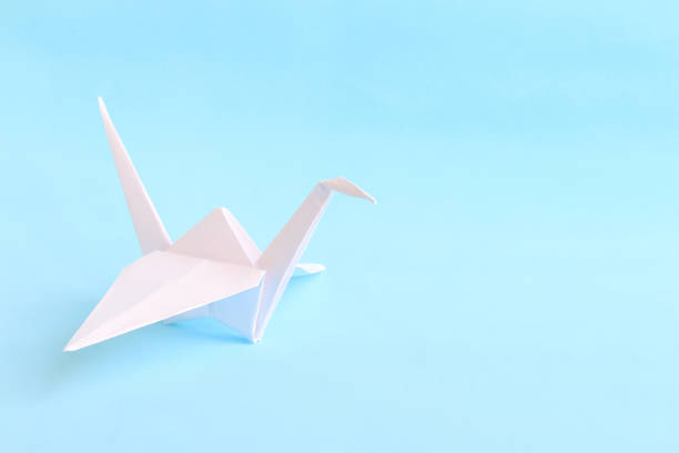 Group of origami birds flying to the light