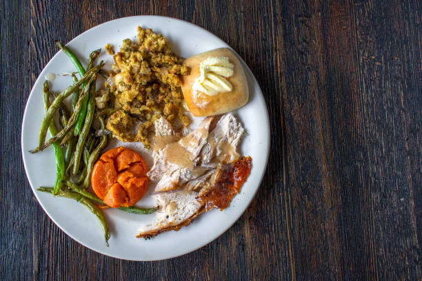 istock plated flat lay white turkey meat with vegetable sides, buttered bread, and gravey 1216030572