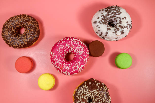 istock Tasty donuts and macaroons on pink background. Top view 1216031687