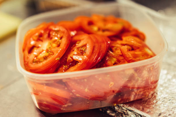 Sliced tomato and red onion at chopping board, close-up, burger making, fresh ingredients