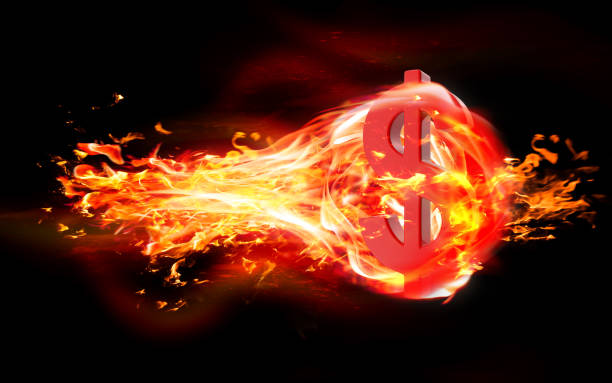 istock Dollar Sign is Burning in Flames Against Black Background 1216036583