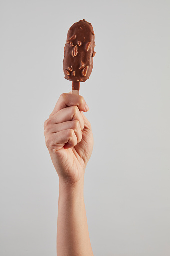 Hand holding Chocolate almonds Ice cream bar isolate on white background