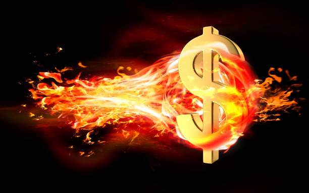 istock Dollar Sign is Burning in Flames Against Black Background 1216036892