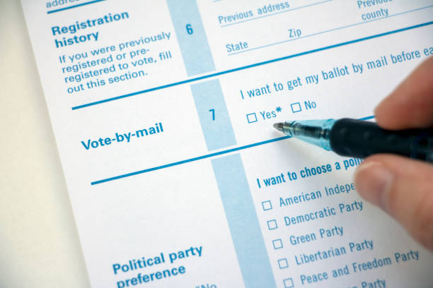 istock Vote by Mail registration with hand holding pen 1216037843