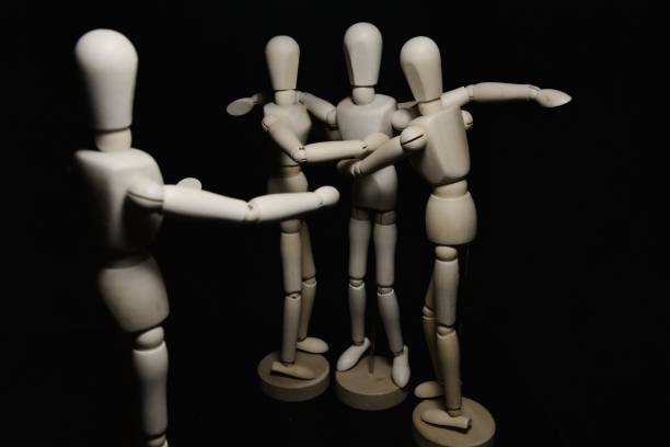istock Two drawing mannequins helping another one to rise and one inciting from afar 1216041835