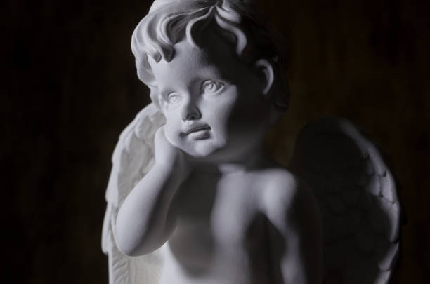 istock Beautiful white angel on black background close-up 1216044529