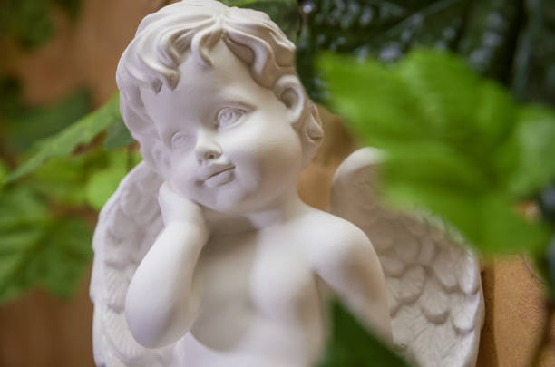 istock Beautiful white Angel among green leaves 1216044538