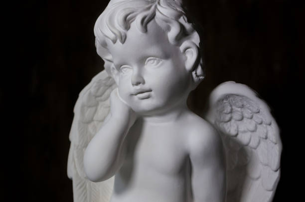 istock Beautiful white angel on black background close-up 1216044717