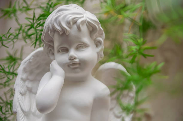 istock Beautiful white Angel among green leaves 1216044730