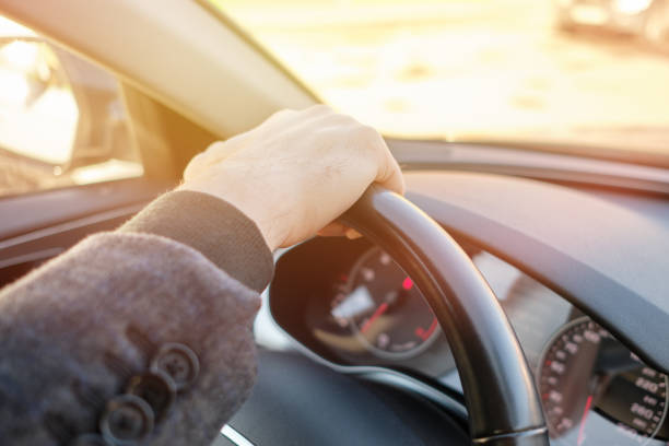 istock A man in a modern car. Hand holds the steering wheel as cool and daring. 1216047080