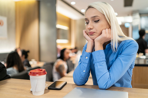 Sad young woman in cafe.