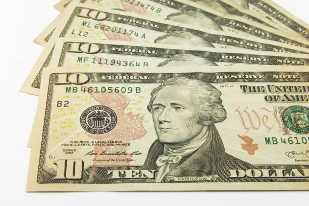 Photo of Stack of American money, ten dollar cash bills on white background