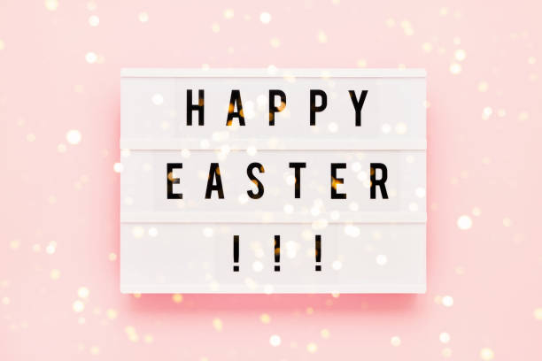istock Easter background. HAPPY EASTER written in light box on pink background. Top view, copy space 1216049098