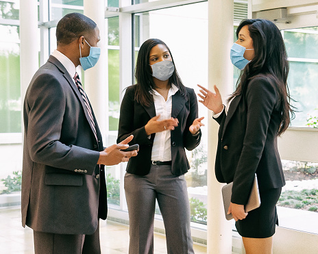 Businessman and businesswomen having a meeting wearing face masks.