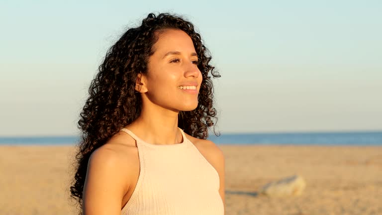 Latin woman breathing fresh air on the beach