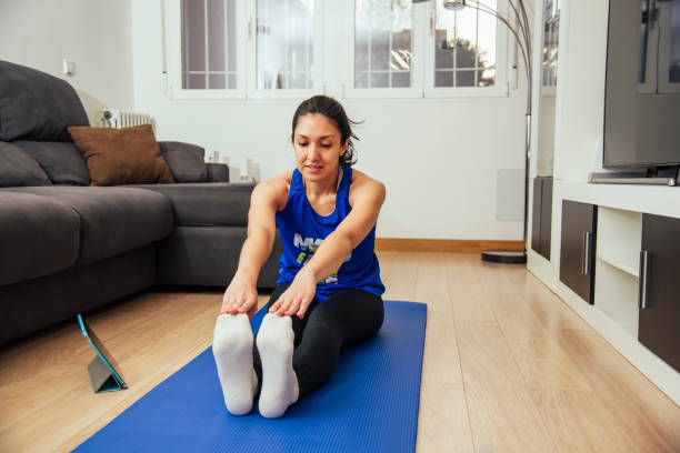 istock Young woman stretching at home 1216050782