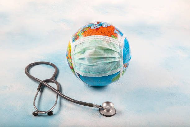 istock Coronavirus. Covid 19. Earth with mask and  stethoscope on the blue background. 1216051081