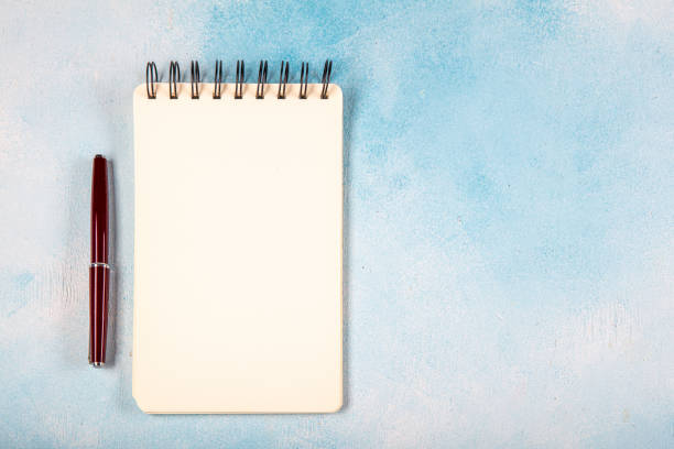 istock Small spiral notebook with fountain pen, isolated on white. 1216055977