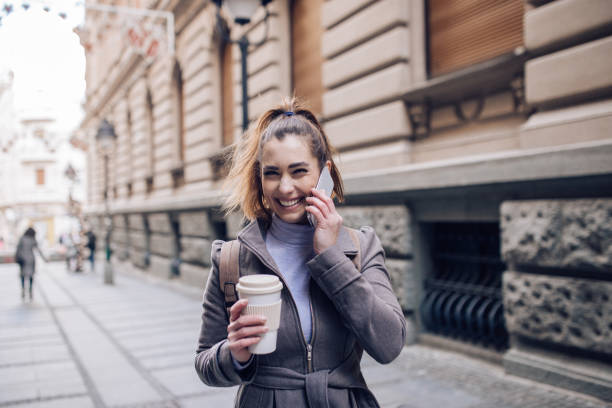 istock Girl holding a coffee and using the phone 1216056425