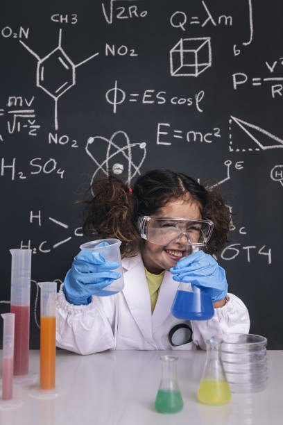 funny scientist child in lab coat laughing funny scientist girl with gloves and goggles in lab coat laughing, blackboard background with science formulas, explosion in the laboratory, back to school concept blackboard child shock screaming stock pictures, royalty-free photos & images