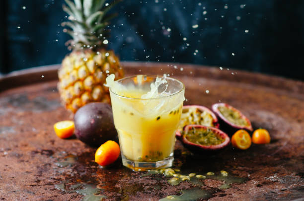 szklanki soku z tropikalnymi owocami na stole na ciemnym tle - pineapple sour taste full tropical climate zdjęcia i obrazy z banku zdjęć