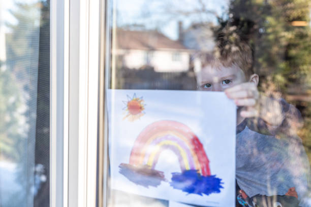 istock Young Boy sticking his drawing on home window during the Covid-19 crisis 1216065286