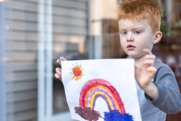 istock Young Boy sticking his drawing on home window during the Covid-19 crisis 1216065337