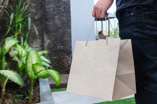 Close up shot of Indonesian delivery workers deliver food to a customer during Covid 19 lockdown