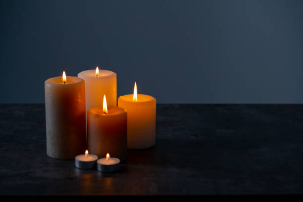 istock Candle lights in the darkness. Some candles burning in dark background. 1216069478