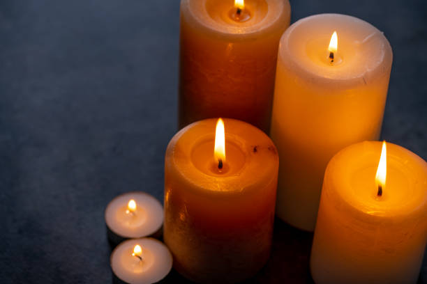 istock Candle lights in the darkness. Some candles burning in dark background. 1216069504