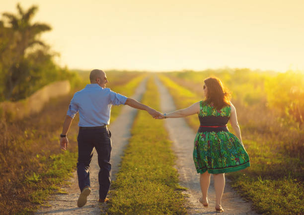 Couple in love enjoy beautiful summer day in the forest. Lens flares are visible.