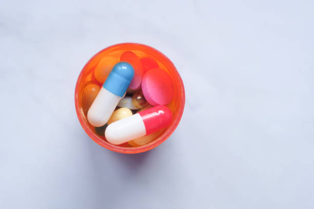 istock top view of pills in a container on white background 1216075758