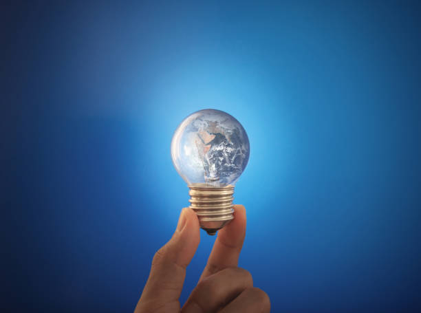 istock Saving energy and earth day concept. Hand holding glowing earth light bulb. Element of this image are furnished by NASA ( https://svs.gsfc.nasa.gov/11650 ) 1216079835