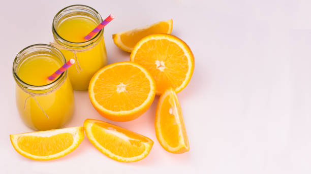 istock Orange juice in jars and fresh oranges on a white background. Copy space. 1216080025