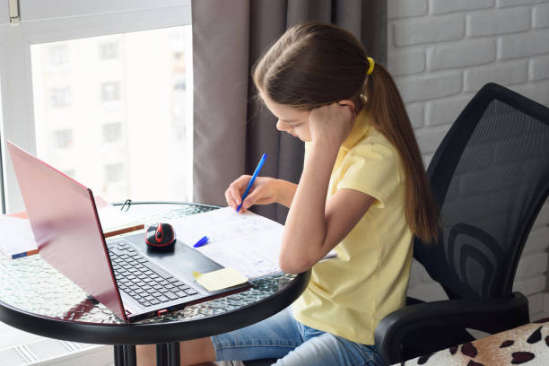 istock Girl at home doing online lessons while sitting at the computer 1216080763