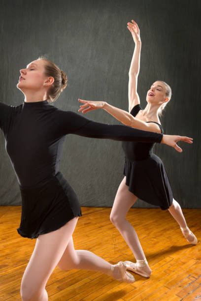 istock Two young woman ballet dancers in a studio photo session. 1216081744