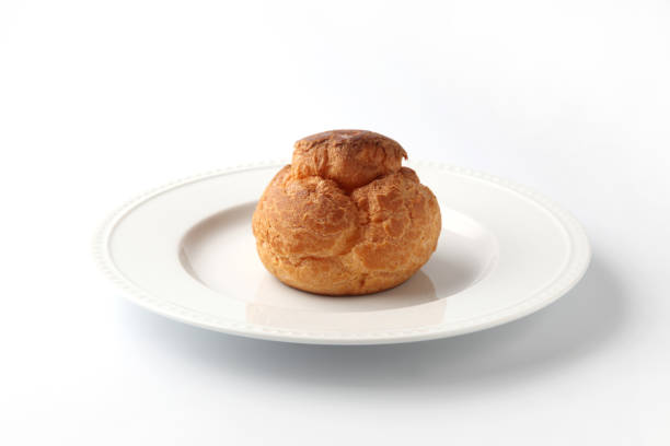 istock cream puff on plate closeup isolated on white background 1216083922
